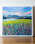 An original acrylic painting of Northumberland in springtime by Joanne Wishart, featuring vibrant pink wildflowers in the foreground, colourful fields, and smoky blue hills under a blue and pink sky.