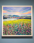 An original acrylic painting of Northumberland in springtime by Joanne Wishart, featuring vibrant pink wildflowers in the foreground, colourful fields, and smoky blue hills under a blue and pink sky.