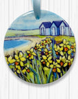 Decorative ornament with a scenic design of Beach Huts and Daffodils on a white background