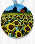 Decorative plate with sunflower field and house design on a white wooden background