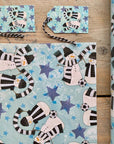 A corner sample of snowmen wrapping paper in Newcastle black and white scarves.