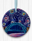A circular ceramic decoration hung against a white background. It features the Tyne Bridge under a dark blue sky of colourful fireworks.