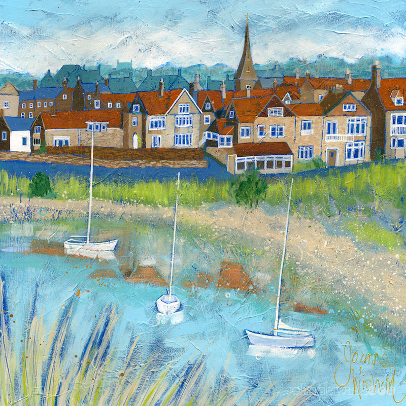 A print of Alnmouth village with the river flowing across the foreground and sailing boats bobbing on the water.