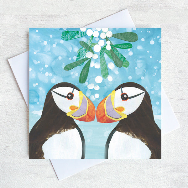 Two puffins kiss under the mistletoe. 