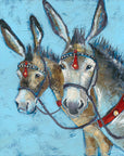 A print of two seaside donkeys bridled up with red accents on the leatherwork.