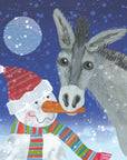 A donkey eats the carrot on a snowmans nose christmas card. There is snow fluttering down a moonlit sky.