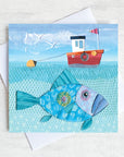 A greetings card featuring a red fishing boat with a big John Dory fish swimming underneath.