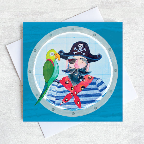 A greetings card featuring a Pirate with a green parrot on his shoulder looking through at the porthole of a ship. 