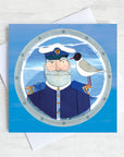 A greetings card featuring a beardy ships captain with a gull on his shoulder peeking through a porthole.
