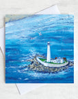 A greetings card featuring a painting of a birds eye view of St Mary's lighthouse surrounded by sea sea at high tide.