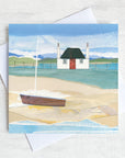 A scottish greetings card featuring a blackhouse cottage on a shore with a boat on the beach.