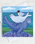 A charming greetings card from an original painting by Joanne Wishart, this joyous picture features a seal pub on its mum back with a friendly seagull snuggled on top!