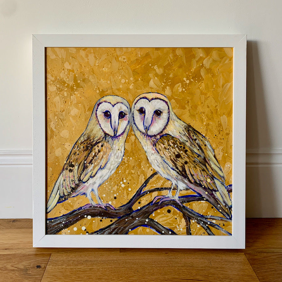 A painting of two barn owls perched on a branch with a leafy ochre beackground. 