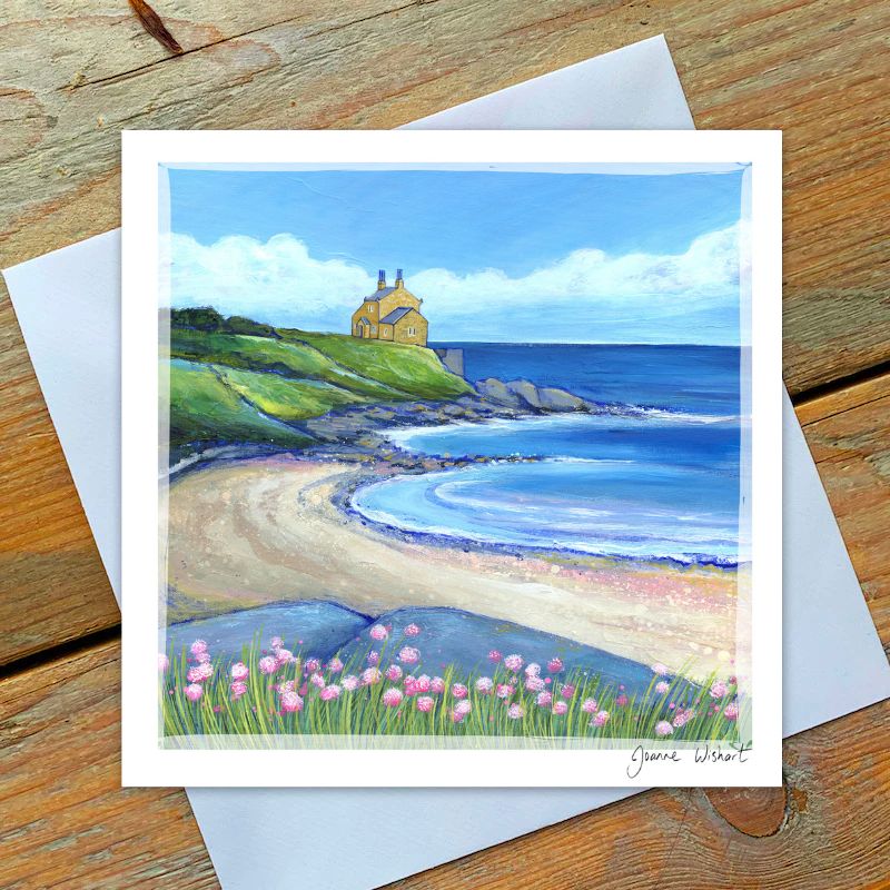 Coastal scene with a bathing house, ocean, and pink flowers in a coastal scape.