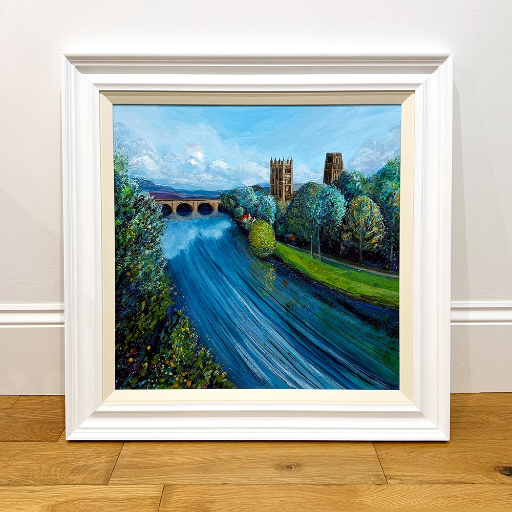 Framed painting of a scenic landscape with a river, bridge, and trees.
