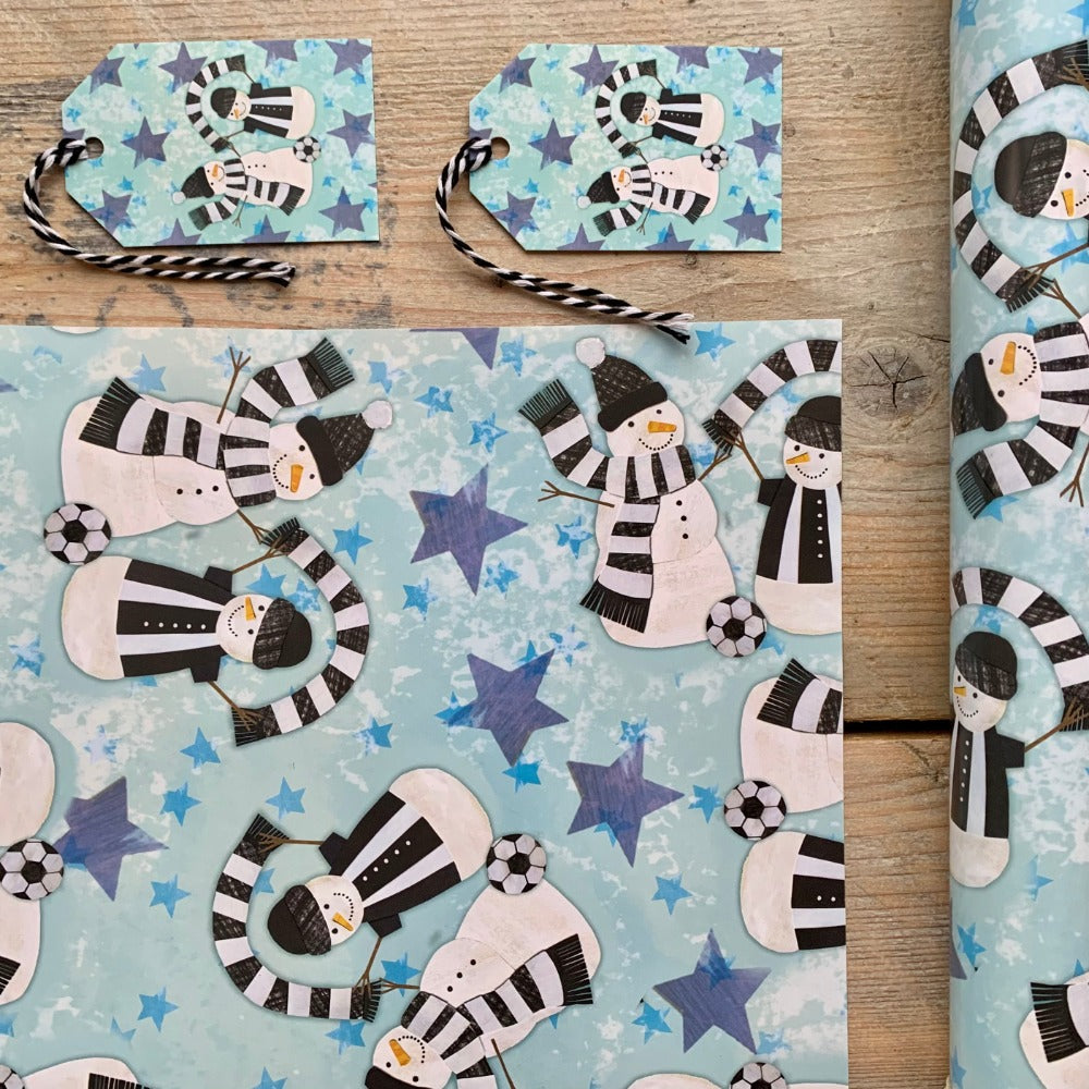 A corner sample of snowmen wrapping paper in Newcastle black and white scarves. 