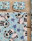 A corner sample of snowmen wrapping paper in Newcastle black and white scarves. 