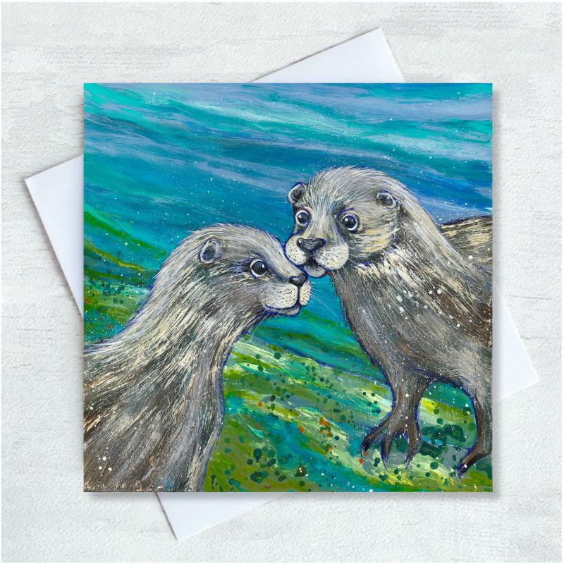 A pair of otters stand face to face on a green river bed against a turquoise watery backdrop.
