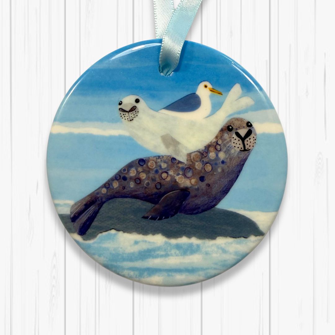 Decorative tree decoration with a seal and bird design on a white wooden background