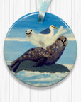 Decorative tree decoration with a seal and bird design on a white wooden background