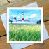 A greetings card featuring a colorful illustration of the Souter Lighthouse with a field of flowers in the foreground, signed by Joanne Wishart.
