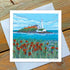 A greetings card featuring an artistic portrayal of St. Mary's Lighthouse with a coastal background and floral elements.
