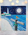 A greetings card featuring a white lighthouse  with a signpost directing people to St Mary's. A robin bird sits on top of the post. 