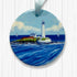 Round ceramic ornament with St Mary's lighthouse design on a white wooden background