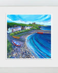 A bright colourful painting of a harbour village in a white woodwash frame