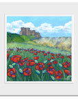 A mounted print of bamburgh castle with a swathe of bright red poppies in the dunes .