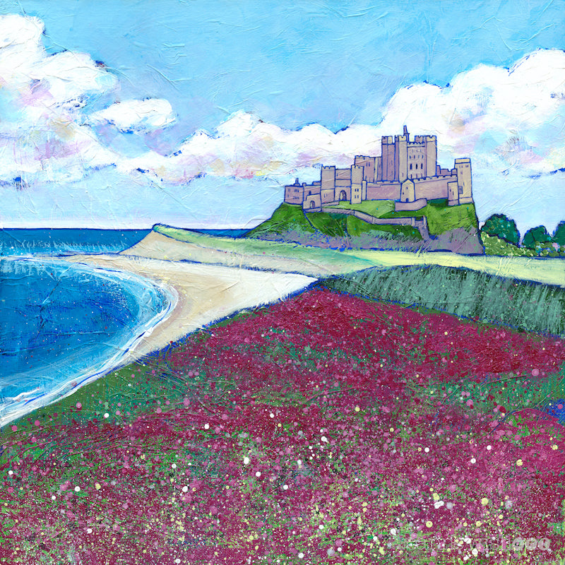 A print of the iconic bamburgh castle perched above a sweeping field of purple wildflowers.