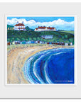 A mounted print of foldingham Bay in the Scottish Borders featuring a row of old beach huts on the sand. 