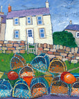 A print of a white fishermans cottage in Craster with a pile of lobster pots in the foreground.