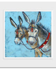 A mounted print of two seaside donkey heads with their ears pricked.