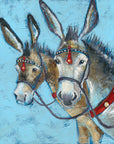 A print of two seaside donkeys bridled up with red accents on the leatherwork. 