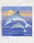 A mum and pup leaping dolphin purple greetings card.