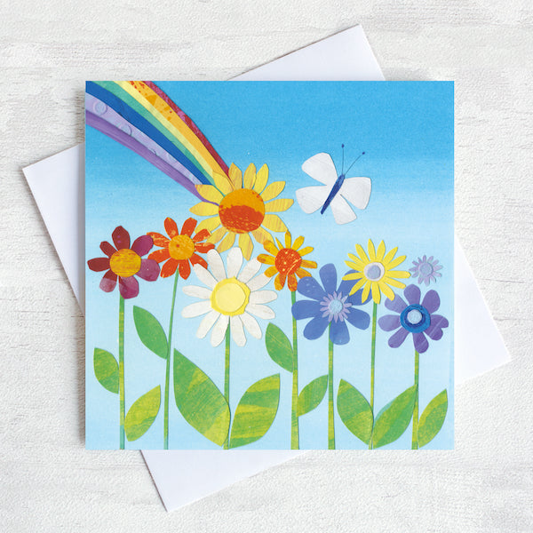A Greetings Card featuring bright retro flowers with a rainbow bursting out from behind.