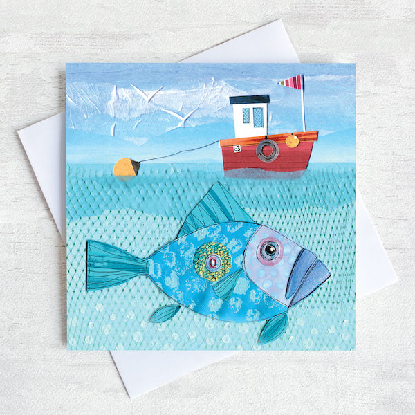 A greetings card featuring a red fishing boat with a big John Dory fish swimming underneath.