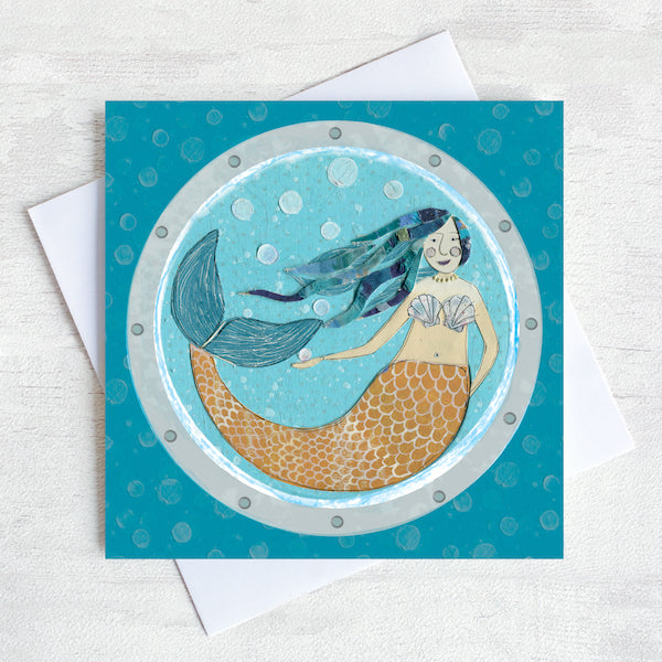 A nautical greetings card featuring a swimming mermaid as seen through a ships porthole.