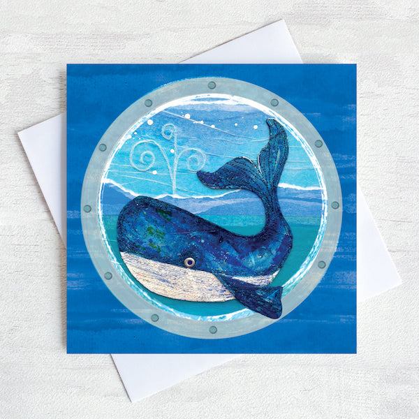 A nautical greetings card featuring a big blue whale as seen through a ships porthole.