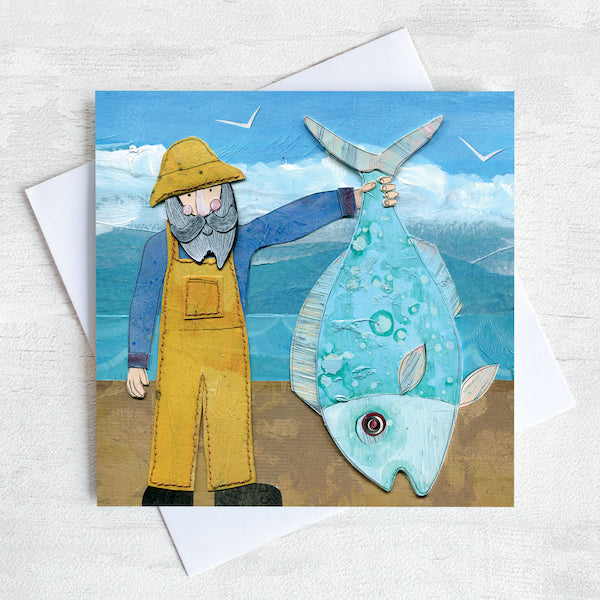 A greetings card featuring a fisherman in yellow dungarees holding up a giant fish!