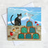 A coastal greetings card featuring a black cat in conversation with a cheeky seagull. They are on a harbour wall surrounded by lobster pots.