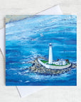 A greetings card featuring a painting of a birds eye view of St Mary's lighthouse surrounded by sea sea at high tide. 