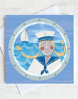 A nautical greetings card featuring a sailor girl with blond pigtails.