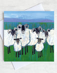 A rural greetings card featuring a quirky flock of sheep  with lambs huddled.