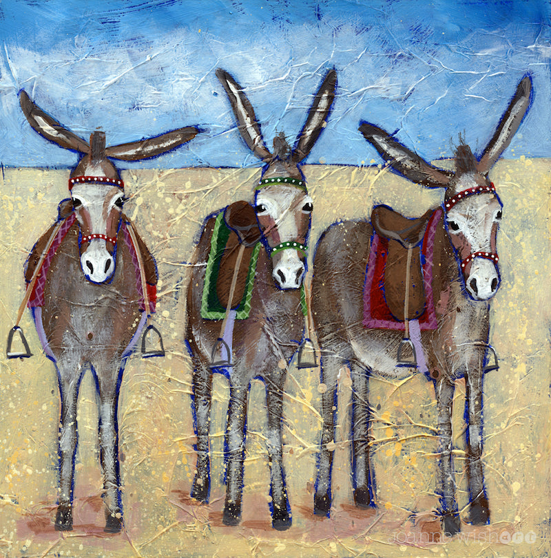 A print of three cute donkeys lined up in row on the beach.