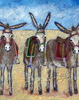 A print of three cute donkeys lined up in row on the beach.