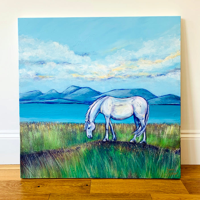 A square landscape painting of a Scottish mountain scene with a turquoise sea running across the middle of the scene. A grey pony grazes on an open grassland in the foreground. 
